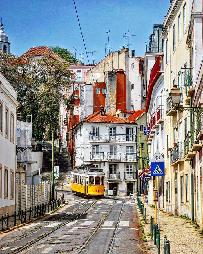tram going down a street in lisbon