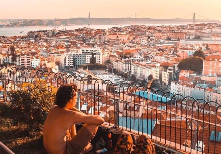 Personas viendo el atardecer desde el Mirador da Senhora do Monte en Lisboa